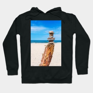 Stack of stones on the beach against blue sky Hoodie